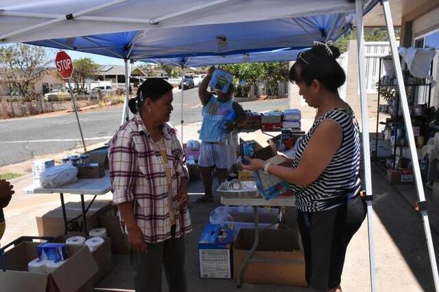 8月22日，在美国夏威夷州毛伊县拉海纳镇，埃尔琳达·拉梅布（右）分发救援物资。新华社发（曾慧摄）