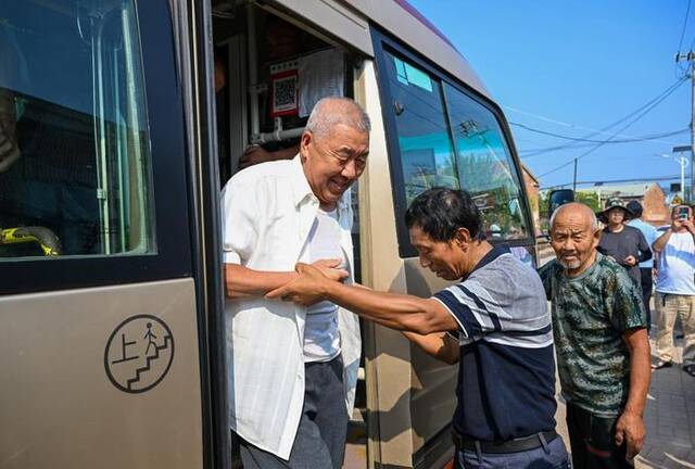 8月17日，在天津市武清区黄花店镇邵七堤村，村委会主任寇之明（左二）迎接村民回村。新华社记者孙凡越摄