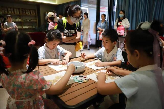 8月6日，参加研学游的学生在位于陕西省西安市的易俗社文化街区体验秦腔戏曲文化。新华社发