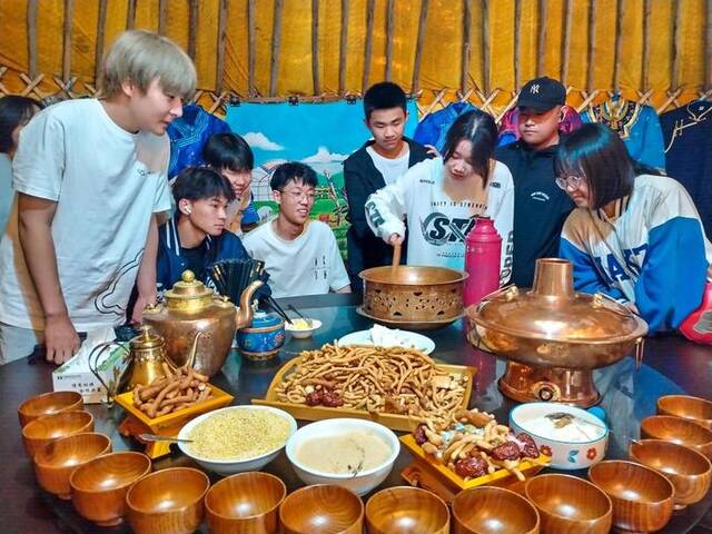 6月20日，游客在乌兰毛都草原上的蒙古包内品尝美食。新华社记者贝赫摄