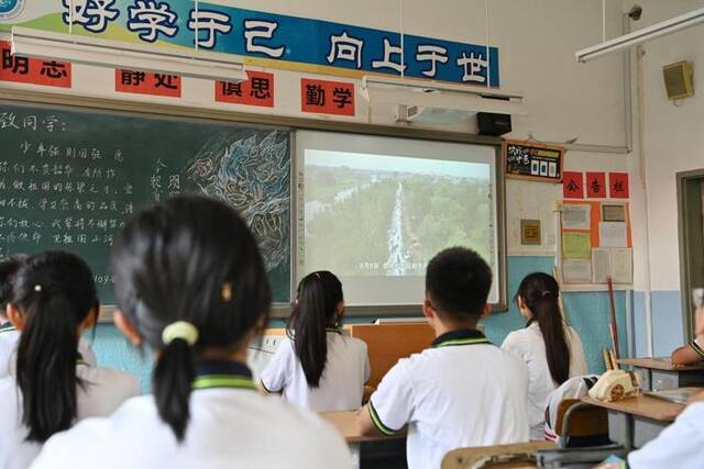9月1日，在天津市静海区实验中学，同学们在开学第一课上观看抗洪视频。新华社记者李然摄