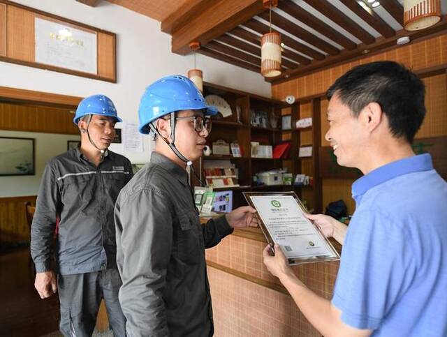 8月11日，电力工作人员给浙江安吉余村的一家民宿颁发绿证。新华社记者翁忻旸摄