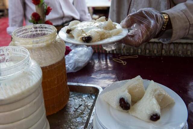 给黏糯清香的粽子上浇上糖稀和酸奶，是新疆巴扎粽子的特色吃法（2017年5月19日摄）。新华社记者沈桥摄