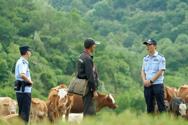 马明（右一）向辖区牧民宣传林区保护相关法律法规（7月28日摄）。新华社发