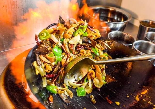在新疆奇台县一家名叫“屯湾锅盔羊汤”的餐厅里，大厨正在制作“爆炒羊杂”（2018年7月25日摄）。新华社记者赵戈摄
