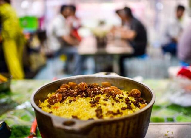 在新疆和田市的夜市里，一锅刚制作好的“小锅抓饭”吸引食客（2017年5月12日摄）。新华社记者赵戈摄