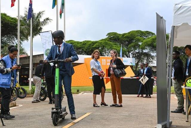 6月6日，在联合国位于肯尼亚首都内罗毕的办事处，人们在低碳和电动交通载具展上参观体验电动滑板车。新华社记者韩旭摄