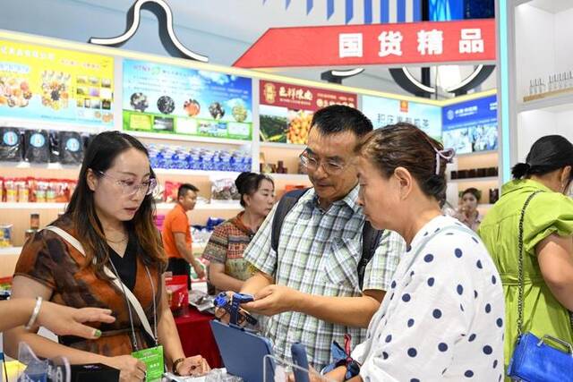 9月6日，游客（中）在第四届中国—蒙古国博览会上选购商品。新华社记者贝赫摄
