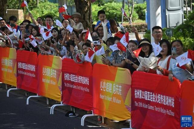 9月9日，观众观看火炬传递。当日，杭州亚运会火炬在湖州传递。新华社记者徐昱摄