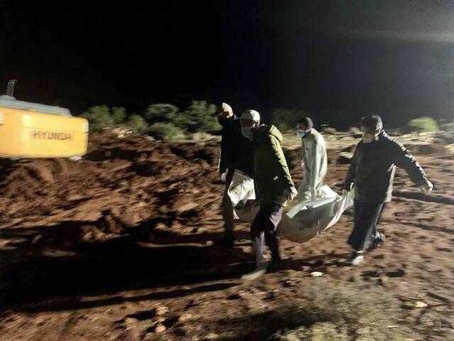 当地时间2023年9月13日，利比亚德尔纳，救援人员正在埋葬洪水遇难者的遗体。图/视觉中国