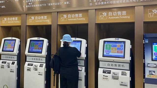 2023年9月13日，北京，北京站售票大厅，旅客使用自助售票机购买车票。新京报-ICphoto图