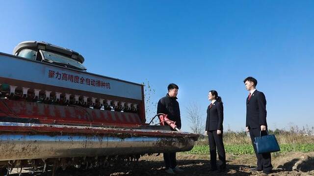 涟水县检察院检察官向种粮大户了解修复后农田的耕种情况及收成。