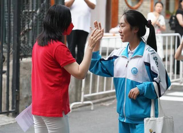 2023年6月24日，在北京一零一中双榆树校区考点，考生进入考点前与老师击掌。新华社记者任超摄