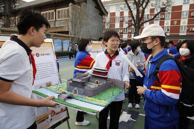 2023年3月14日，在北京市第五中学分校，学生展示参与设计制作的“北京中轴线”景观沙盘作品。新华社发（周良摄）