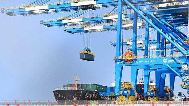 2023年2月25日，在广西钦州港自动化集装箱码头，塔吊在运送集装箱。新华社记者张爱林摄