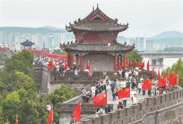 9月30日，湖北襄阳古城景区、街头挂上一面面五星红旗，喜庆气氛吸引不少游客前来游览拍照。图片来源：视觉中国