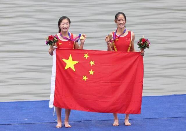 9月24日，杭州亚运会首金的获得者、中国赛艇运动员邹佳琪（左）/邱秀萍在颁奖仪式上庆祝。新华社记者杜潇逸摄