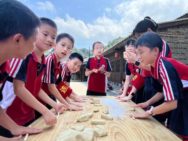 江西永新县曲白乡白沙村大井冈研学基地里小游客们正在体验劳动实践。（刘昕哲摄）