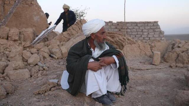10月7日，在阿富汗赫拉特省，一名老人坐在自家坍塌的房屋前。新华社发（马沙勒摄）