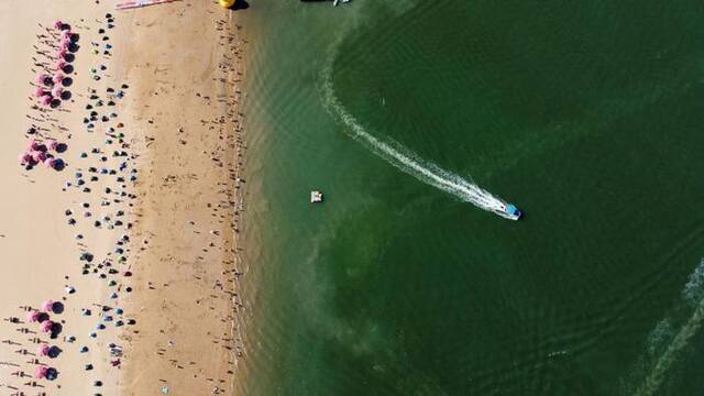 游客在天津市滨海新区东疆港人工沙滩游玩（无人机照片）。新华社记者赵子硕摄