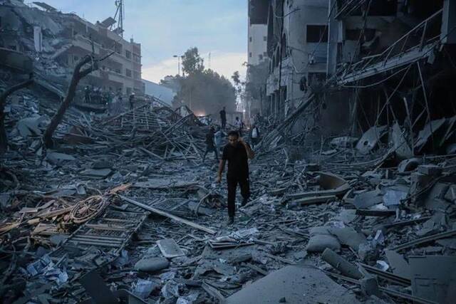 ▲10月7日，巴勒斯坦民众在加沙城查看以色列空袭后毁坏的民宅图据新华社