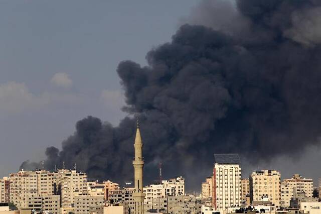 10月11日，加沙城的建筑遭以色列空袭后升起浓烟。