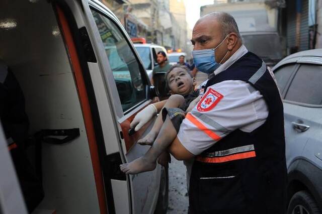 10月19日，在加沙地带南部城市汗尤尼斯，人们在遭以色列空袭后的建筑废墟中救援伤者。新华社发（亚西尔·库迪摄）