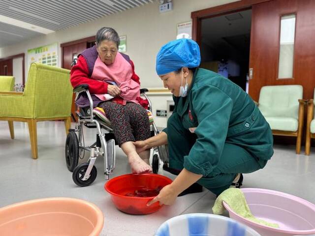 10月17日，在西宁市城西区通海路街道综合养老服务中心，护理员正在为老人洗脚。新华社记者张子琪摄