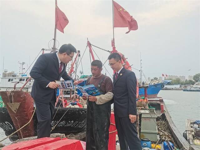 图②:秦皇岛市海港区检察院检察官走码头上船头,向渔民宣讲海洋保护知识和公益诉讼检察职能。