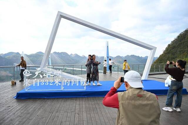 10月25日，游客在“天空之桥”观光服务区拍照留念。新华社记者胡智轩摄