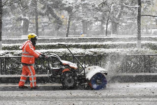 11月6日，在长春市人民大街，环卫工人操作清雪机清理路面积雪。新华社记者张楠摄