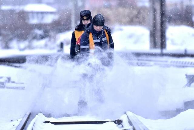 工人们在为铁轨清雪。（中国铁路哈尔滨局集团有限公司供图）