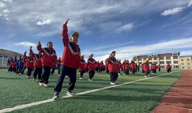 10月13日，在西藏那曲市班戈县中石化小学，学生在操场上跳“班戈谐钦”课间操。新华社发（王敬摄）
