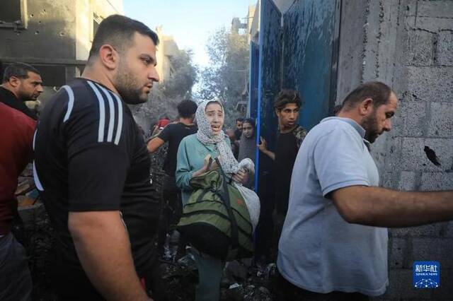 11月6日，人们从加沙地带中部地区一处被炸难民营逃离图：新华社