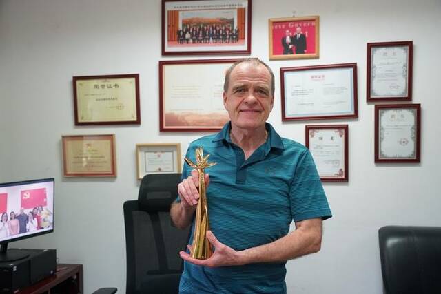 大卫·弗格森在办公室向记者展示他所获得的兰花奖奖杯。新华社记者朱昊晨摄