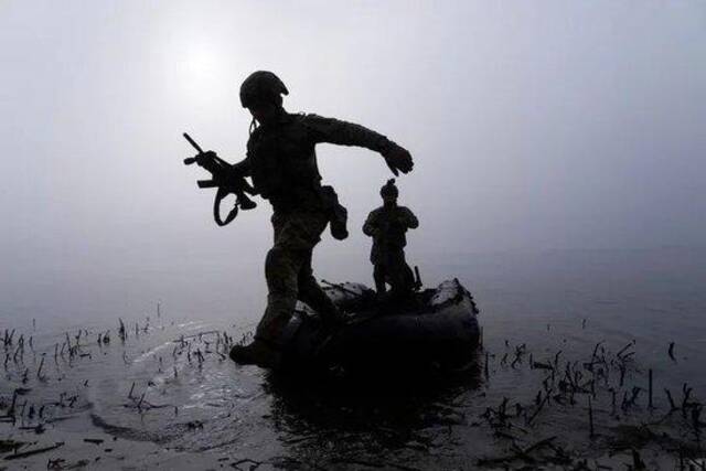 ▲10月15日，在乌克兰赫尔松附近的前线，一名乌克兰军人在第聂伯河岸边跳下船。（美联社）