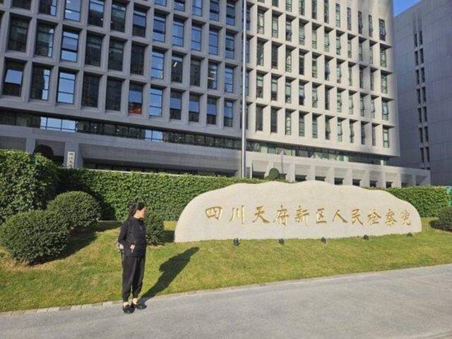 丹丹的母亲彭女士在天府新区检察院门口。上游新闻记者李文滔摄