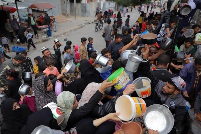 11月19日，在加沙地带南部城市拉法，人们领取救济食物。新华社发（里泽克·阿卜杜勒贾瓦德摄）