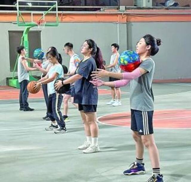 广州市青年文化宫内，夜校学生在学习花式篮球技巧。光明图片
