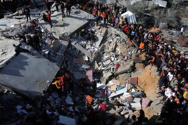 11月23日，人们聚集在加沙地带南部城市拉法一处废墟上。新华社发（哈立德·奥马尔摄）