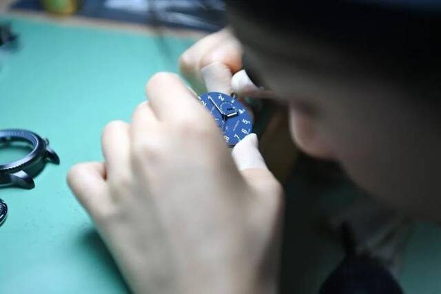今年5月，天津海鸥表业集团生产车间内，员工在操作台前组装手表图片来源：新华社