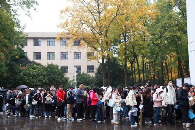 2023年11月26日，江苏省南京市，国考公共科目笔试考点外，考生在等候进场。IC图