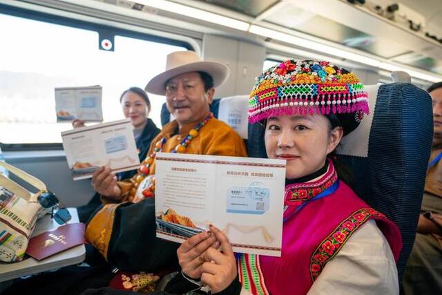 11月26日，乘坐丽香铁路开通首发列车的嘉宾在车厢内展示纪念车票。新华社记者陈欣波摄