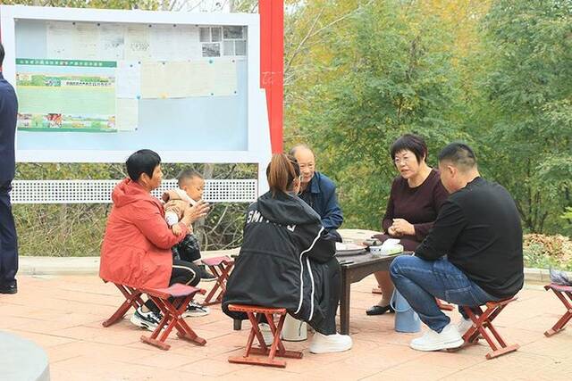 朱明香代表(右二)与凰山社区居民围坐在一起拉家常,收集群众问题意见。