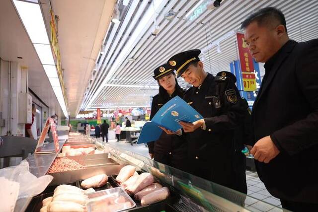 执法人员正在检查猪肉区域的台账。新京报记者王飞摄