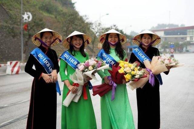 今年3月15日，越方工作人员在越南谅山省的友谊国际口岸手捧鲜花欢迎中国游客。新华社记者胡佳丽摄