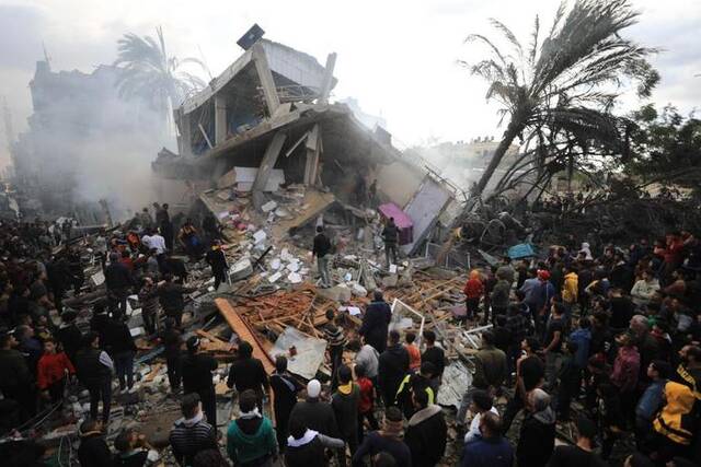 12月14日，在加沙地带南部城市拉法，人们在以军空袭后的建筑废墟上开展救援。新华社发（亚西尔·库迪摄）