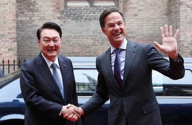 当地时间12月13日，在荷兰海牙首相府，韩国总统尹锡悦（左）与荷兰首相吕特握手并合影留念。图自韩媒