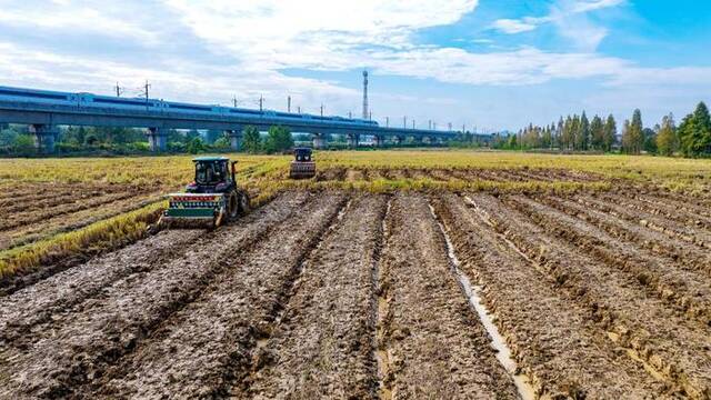 图为在吉安市吉水县八都镇毛家村，农机手驾驶耕种肥一体机播种油菜。（廖敏摄）