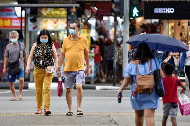 资料图：新加坡民众戴着口罩在街头行走。图/ICphoto